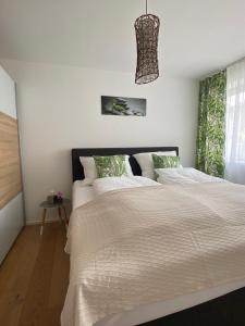 una camera da letto con un grande letto con lenzuola bianche di Adria Villa Apartment family and friends a Velden am Wörthersee
