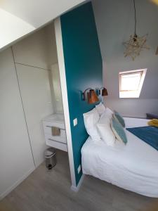 een slaapkamer met een bed met een blauwe accentmuur bij Chambre d'hôtel tout confort au Pays des Abers in Plouguerneau