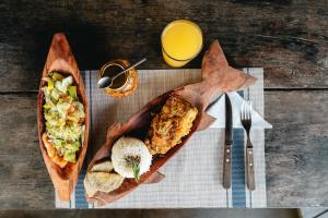 una mesa con un plato de comida y un vaso de zumo de naranja en El Vijo Surf, en Nuquí