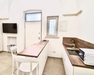 a kitchen with a wooden counter top and a sink at Teorema Suites in Nardò