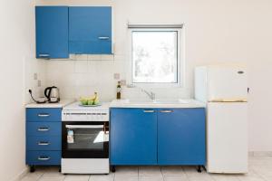 a kitchen with blue cabinets and a white refrigerator at Alexandros Luxury Apartments Nydri in Nydri