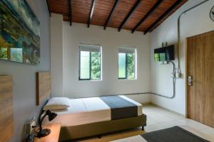 a bedroom with a bed and a tv and windows at Med la palma in Medellín