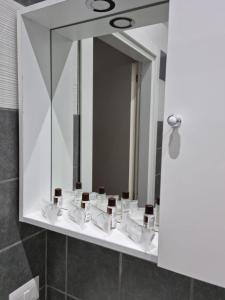 Un baño con espejo y lavabo blanco. en Appartamenti a Gallipoli, en Gallipoli 68 fotos más