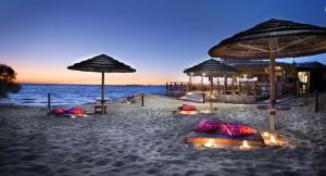 Una playa con sombrillas y sillas y el océano. en Appartamenti a Gallipoli, en Gallipoli