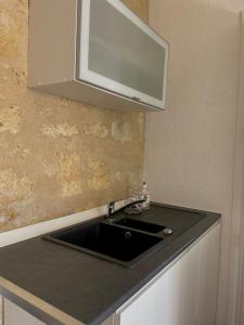 eine Küchenspüle mit einer Mikrowelle darüber in der Unterkunft Maisonzen in Pugnac