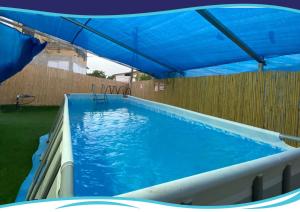 a swimming pool with a blue canopy over it at "הפינה שלי בטבריה" in Tiberias