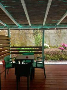 Curpi de Ma في بوناسولا: طاولة وكراسي على سطح خشبي مع طاولة وكراسي