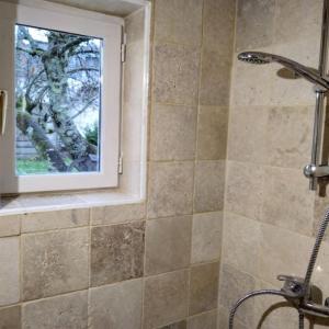a bathroom with a shower and a window at Maisonnette de charme climatisée in La Machine
