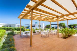 a wooden pergola with tables and chairs on a patio at Tres Estrellas in Gavà