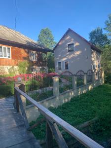 une maison avec une clôture devant une cour dans l'établissement Котедж, à Podobovets