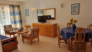 a living room with a dining table and a television at Meia Praia in Lagos +33 photos