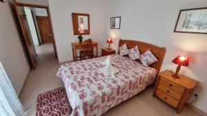 a bedroom with a bed with a red and white bedspread at Meia Praia in Lagos