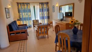 a living room with a dining room table and a television at Meia Praia in Lagos