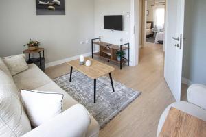 uma sala de estar com um sofá branco e uma mesa em Dolphin Residences - Yasemin 1 em Bodrum City