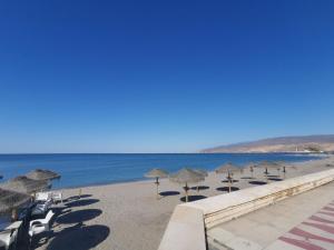 a beach with umbrellas and chairs and the ocean at Casita Lulu en pleno centro con wifi in Almería