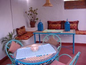 tavolo e sedie in una stanza con tavolo e tavolo di Casa La Palma a Chefchaouen