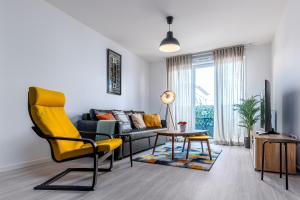 ein Wohnzimmer mit einem Sofa und einem gelben Stuhl in der Unterkunft Appartement lumineux de standing in Drancy