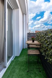 balcón con mesa y suelo verde en Appartement lumineux de standing, en Drancy