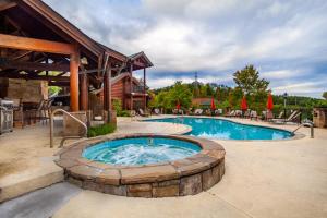 a large swimming pool with a fire pit next to a building at Higher Ground Condo with Mountain and Golf View in Pigeon Forge
