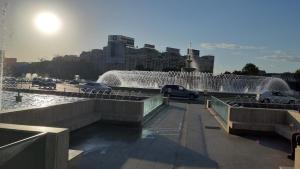 una fuente de agua en una ciudad con coches en un puente en Studio Timpuri Noi 50, en Bucarest