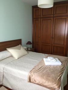 1 dormitorio con 1 cama con 2 toallas en PASEO DO MACEIRAS, en Redondela