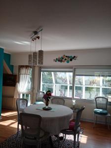 a dining room with a table and chairs and a window at la frégate blanche in Concarneau