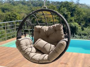 a hanging chair on a deck next to a pool at Sobrado piscina bem localizado 5 min do Flamboyant in Goiânia
