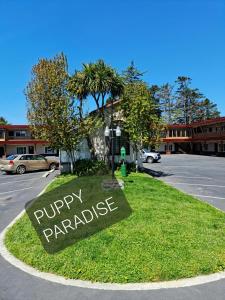 Una señal que dice paraíso de cachorros en un campo de hierba en North Coast Inn, en Crescent City