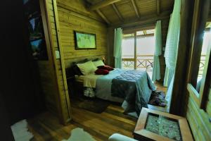 a bedroom with a bed in a log cabin at Pousada Village dos Canyons in Praia Grande +72 photos