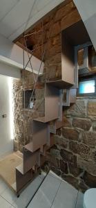 a staircase in a room with a stone wall at Il Gelsomino in Castelmezzano