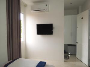 um quarto com uma televisão de ecrã plano na parede em Oasis Nha Trang Hotel em Nha Trang