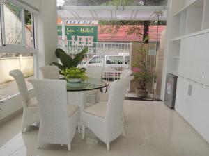uma sala de jantar com uma mesa de vidro e cadeiras em Oasis Nha Trang Hotel em Nha Trang