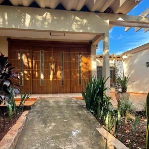 una casa con una puerta de madera y algunas plantas en Morada da Lua en Foz do Iguaçu