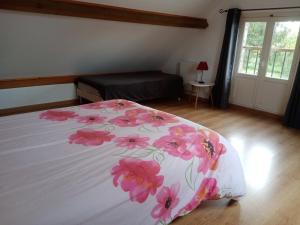 Courtemaux的住宿－Chez Magali，一间卧室配有一张带粉红色花卉床罩的床。