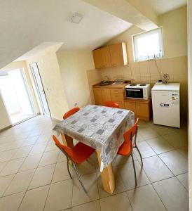 une cuisine avec une table et des chaises orange et une cuisine avec une cuisinière dans l'établissement Centar Apartments, à Dojran
