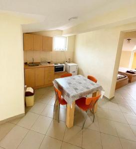 a kitchen with a table and some orange chairs at Centar Apartments in Star Dojran