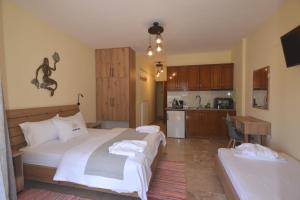 a hotel room with two beds and a kitchen at Vasiliki Blue in Vasiliki
