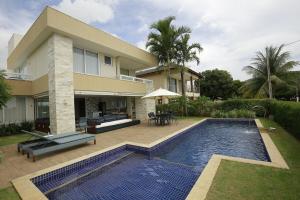 カマサリにあるCasa Luxo Temporada - 5 quartos - Guarajuba - Academia - Piscina e Vistaの家の前にプールがある家