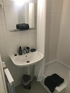 a white bathroom with a sink and a mirror at Roland apartment WestND in Budapest