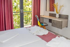 a bedroom with a bed and a desk and a chair at Albertoshouse in Skiathos Town