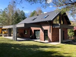 ein Backsteinhaus mit Mansarddach in der Unterkunft FORESTHOUSE in Łubowo