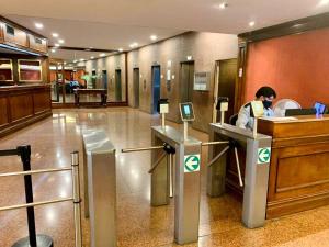 a man working at a counter in a hotel lobby at Obelisco 818 in Buenos Aires