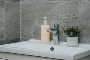 Un lavabo de baño con una botella de jabón y un grifo. en Apartments Bella Rosa, en Budva 33 fotos más