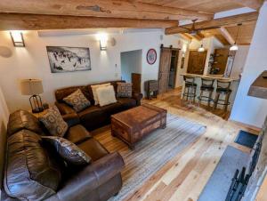 a living room with a leather couch and a table at Jackson Hole Hideout in Wilson