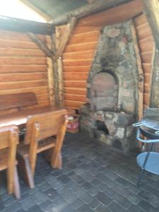 a room with a fireplace with a table and a bench at Domek Rokitki in Rokity +28 photos