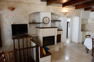 - un salon avec une cheminée et une horloge murale dans l'établissement Dimora Monte Grappa, à Alberobello
