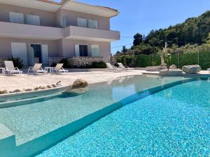a swimming pool in front of a house at Ninfas del Mar in Agios Nikitas