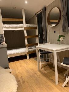 a room with bunk beds and a table and a desk at Swaledale Shepherd's Hut in Newton Abbot