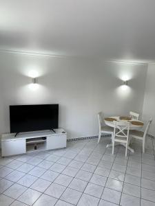 salon ze stołem i telewizorem z płaskim ekranem w obiekcie Relaxing 2 Bedroom House 5 minutes away from Vilamoura Marina w mieście Quarteira