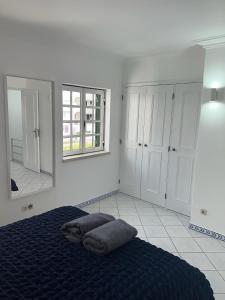 een slaapkamer met een bed en een grote spiegel bij Relaxing 2 Bedroom House 5 minutes away from Vilamoura Marina in Quarteira